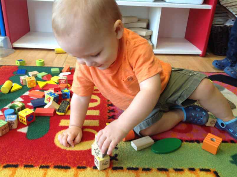 infant playing with blocks